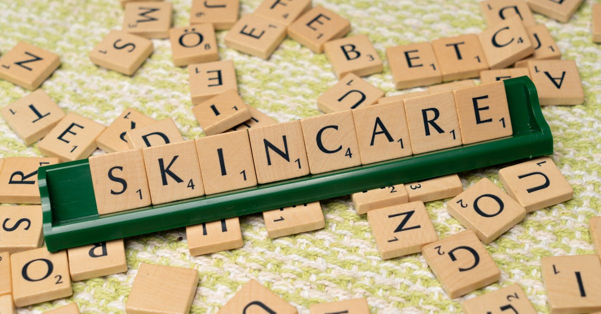 Scrabble tiles spelling 'skincare' on a green textured surface, representing beauty and wellness.